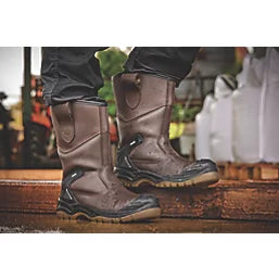 Apache AP305 Unisex Rigger Boots Brown side view showing pull-on design and rubber sole on a worksite.