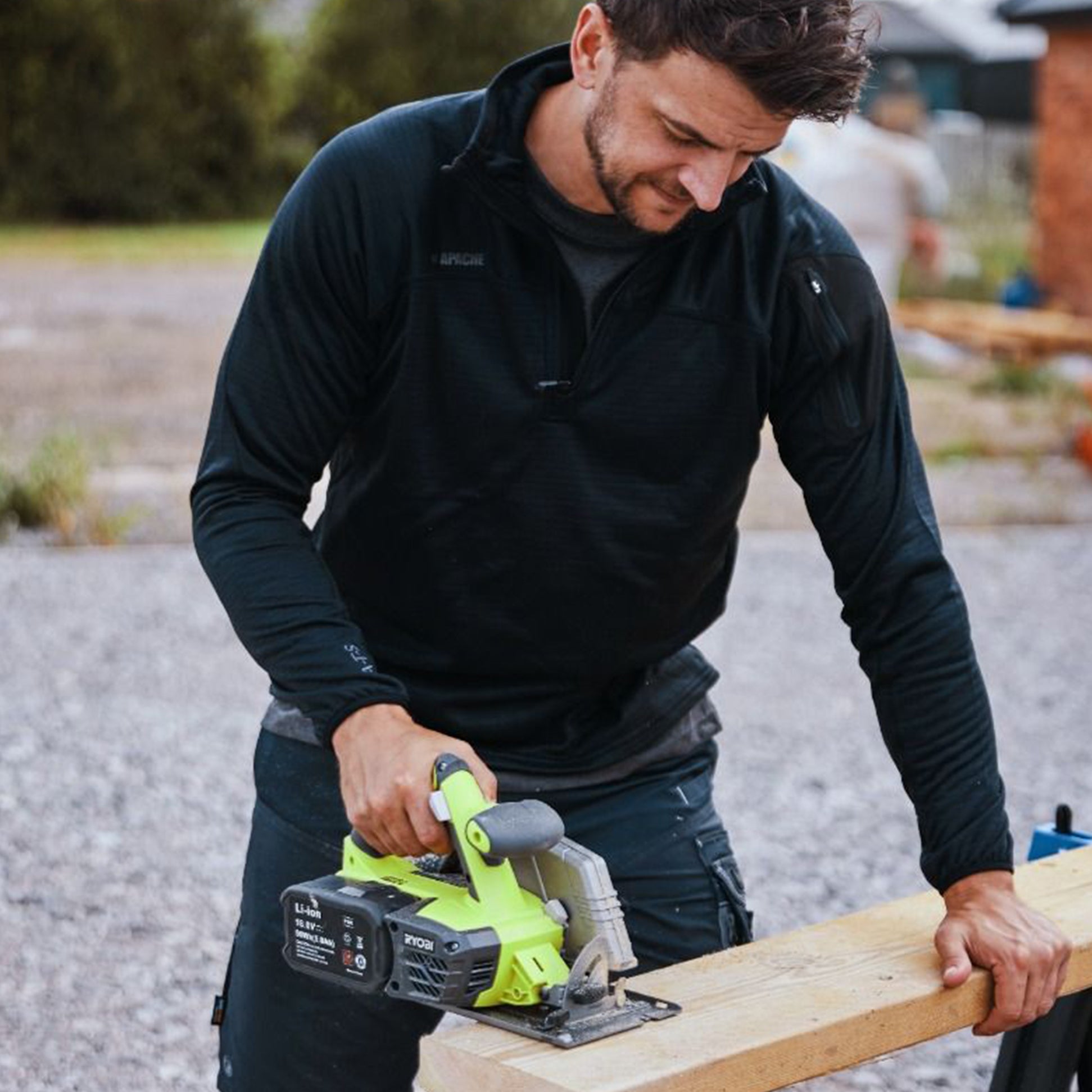 Apache ATS TECH Mens Quarter-Zip Fleece Black, front view of man using a saw, showcasing the fleece's features.