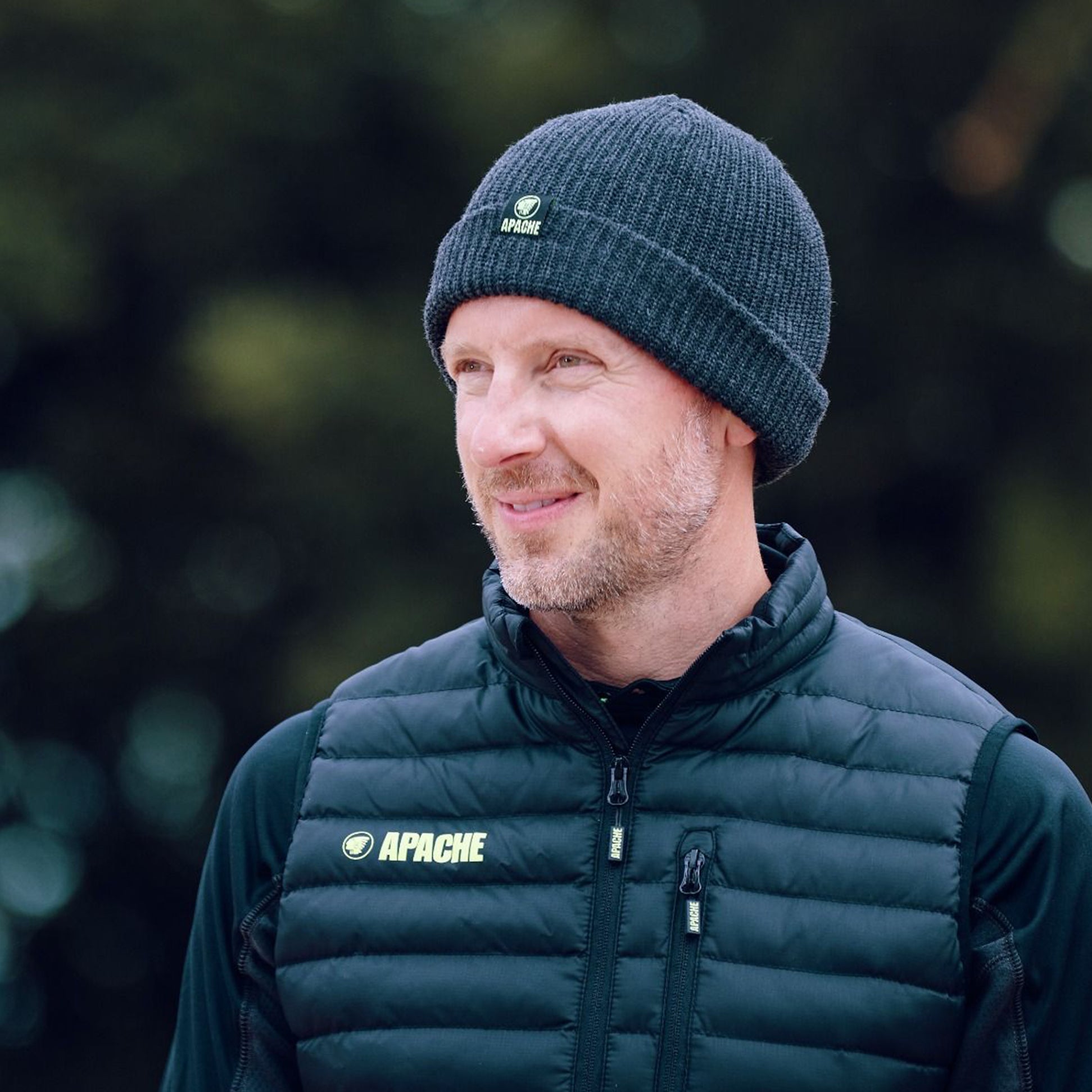 Apache DAWSON Unisex Workwear Beanie Hat Charcoal Grey side view worn by a man with a smile outdoors.