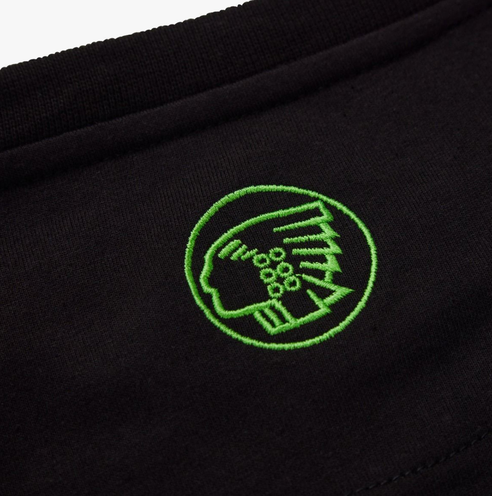 Apache DELTA Mens Workwear T-Shirt Black detail view of debossed logo on fabric, showcasing green embroidery.