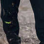 Apache QUEBEC Mens Over Trousers Black side view showing logo detail on fabric with dirt stains.