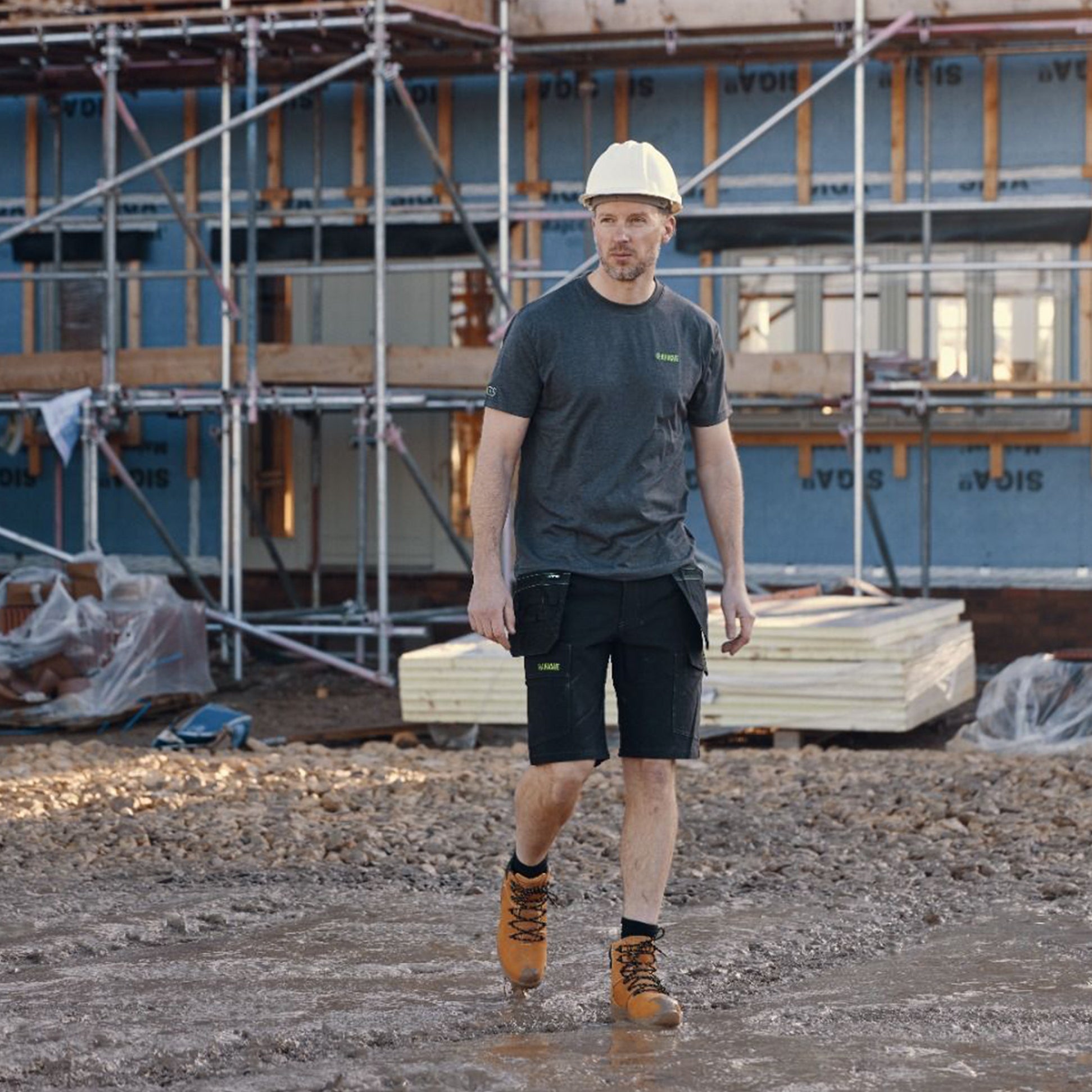 Apache VANCOUVER Mens T Shirt Grey front view on a construction site, worn with black shorts and safety gear.