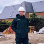 Apache WELLAND Mens Work Jacket Black Charcoal front view on model at construction site, wearing hard hat.