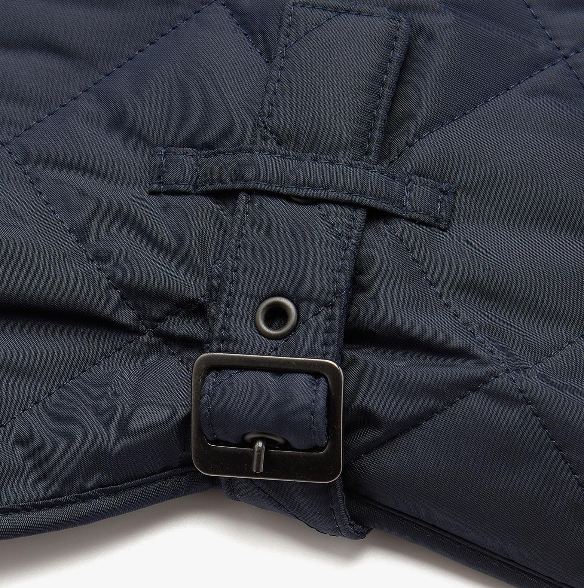 Barbour QUILTED DOG COAT Navy detail view showcasing adjustable buckle strap and quilted fabric.