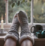 Barbour CABLE KNIT LOUNGE Socks Womens Light Grey Marl front view on a windowsill with candle and mug