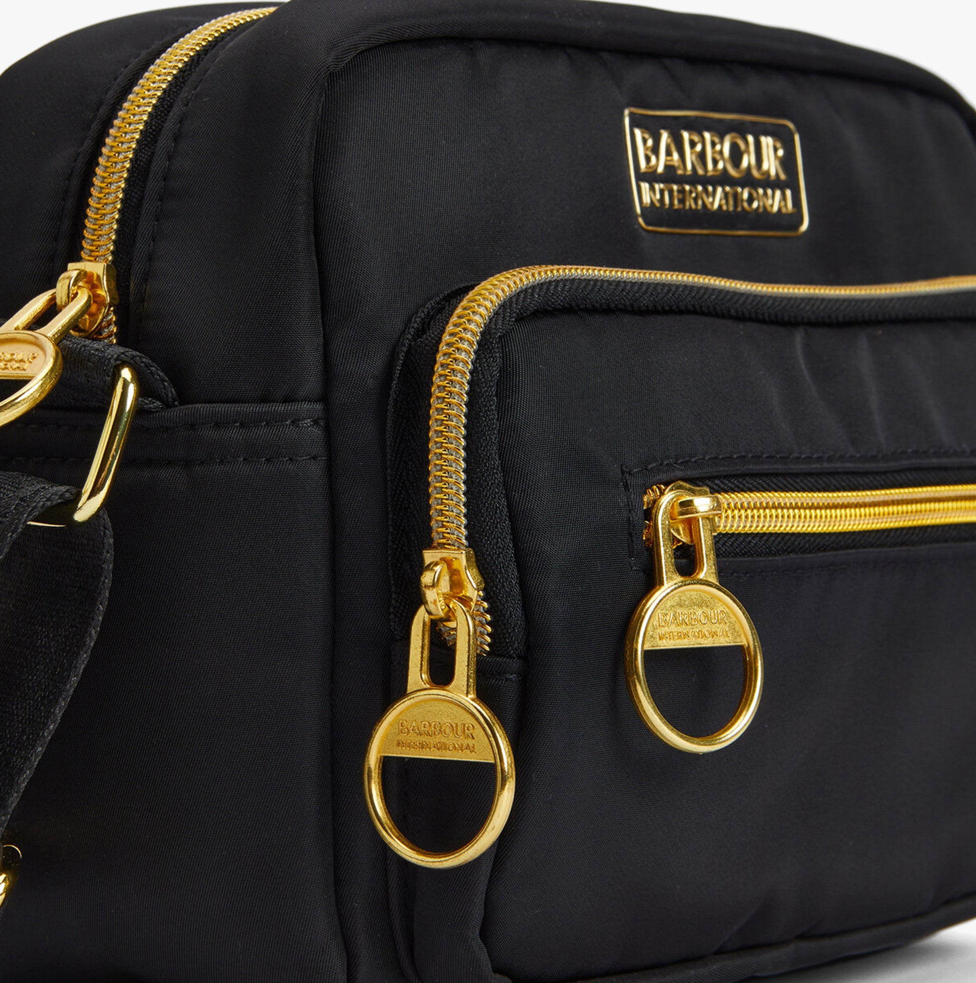 Barbour B.INTL QUALIFY Womens Crossbody Bag Black detail view showing gold zippers and logo.