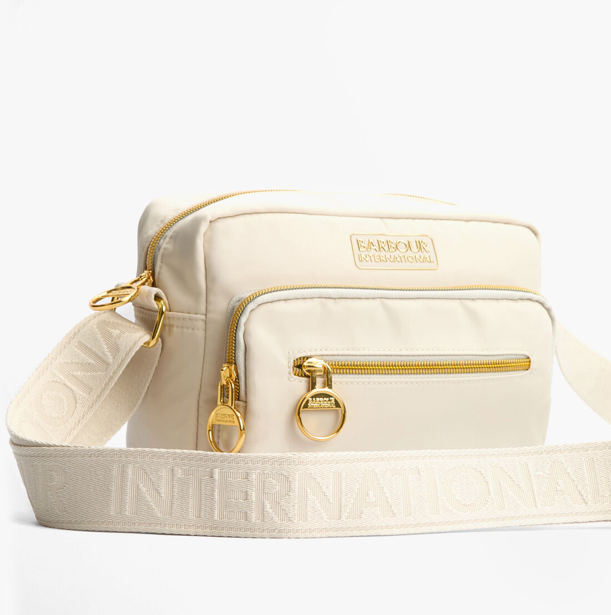 Barbour B.INTL QUALIFY Womens Crossbody Bag Light Pearl front view with gold zippers and adjustable strap