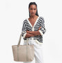 Barbour OLIVIA Womens Tote Bag Light Sand front view, model holding bag, wearing striped cardigan.