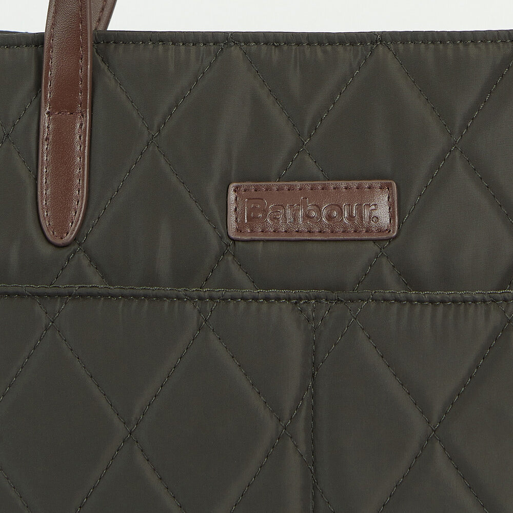 Detail view of Barbour QUILTED Womens Tote Bag Olive showcasing the logo and fabric texture.