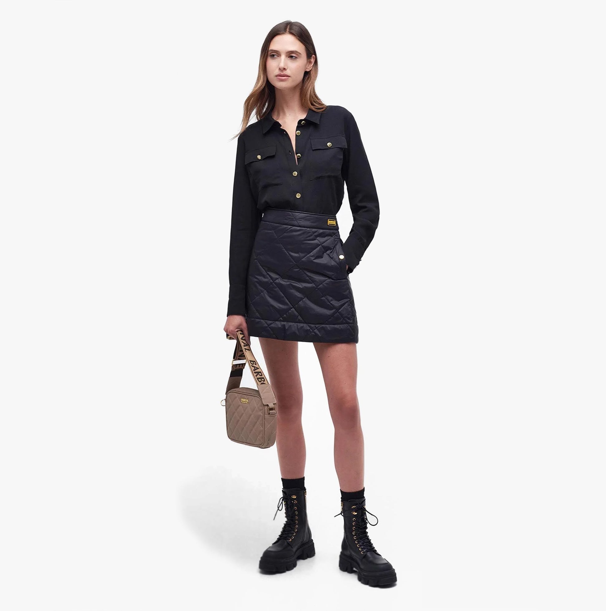 Barbour QUILTED SLOANE Womens Crossbody Bag Camel shown in front view with a model wearing a black shirt and skirt.
