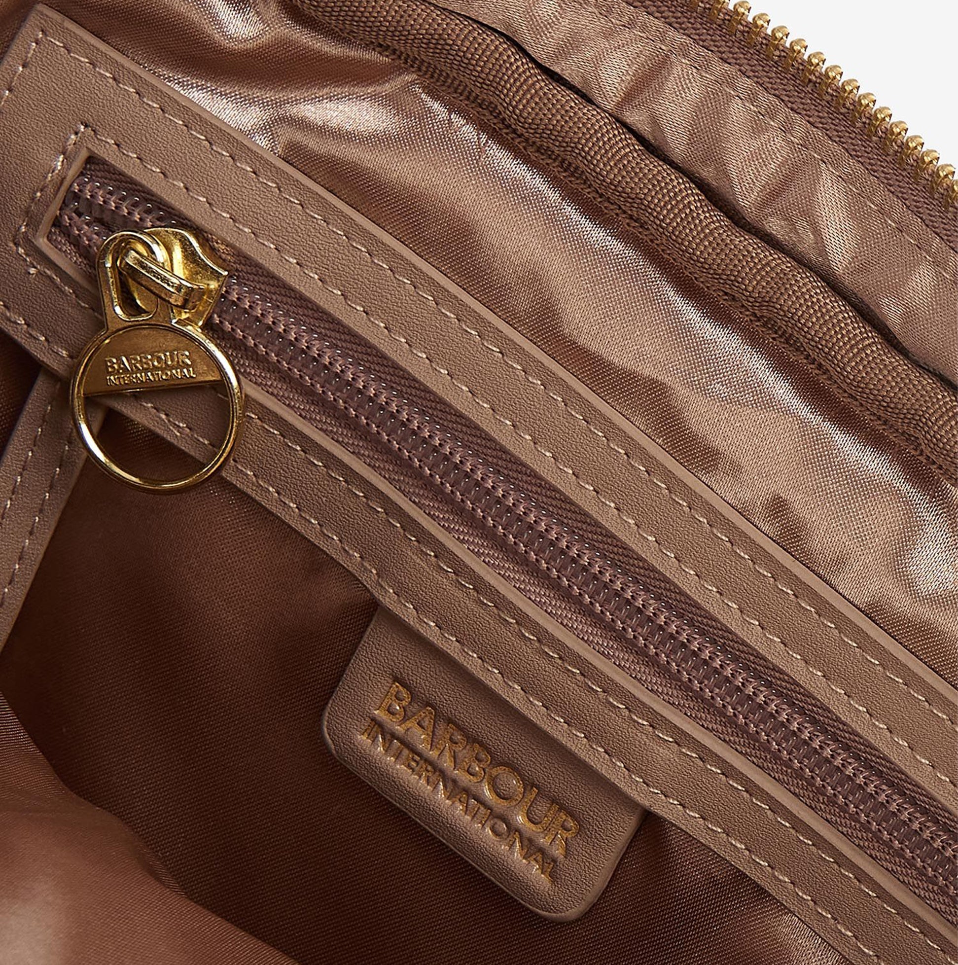 Interior detail view of Barbour QUILTED SLOANE Womens Crossbody Bag Camel showing zip and logo.