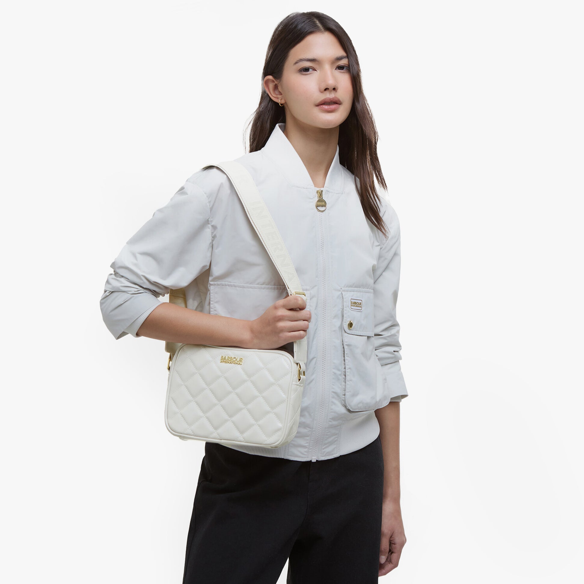 Barbour B.INTL QUILTED SLOANE Womens Crossbody Bag Gloss Silver Birch front view worn by model.