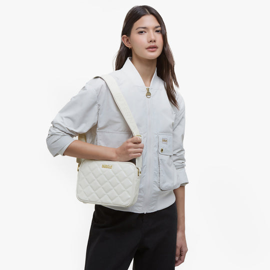 Barbour B.INTL QUILTED SLOANE Womens Crossbody Bag Gloss Silver Birch front view worn by model.