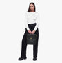 Barbour QUILTED HOXTON Womens Backpack Black front view, model holding bag, highlighting quilted design and gold-tone logo.