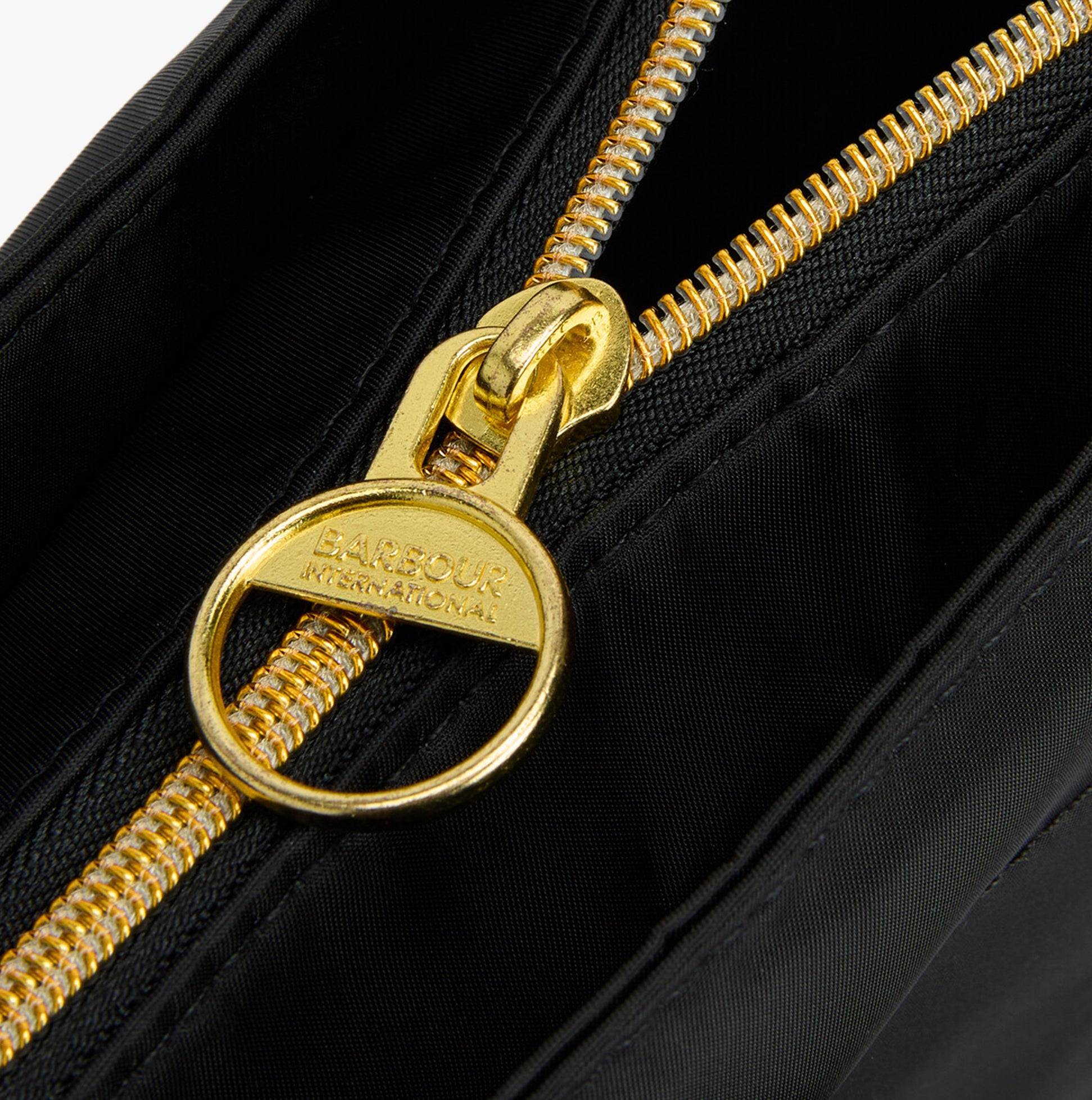 Detail view of Barbour B.INTL QUALIFY Womens Tote Bag Black zipper with gold hardware.