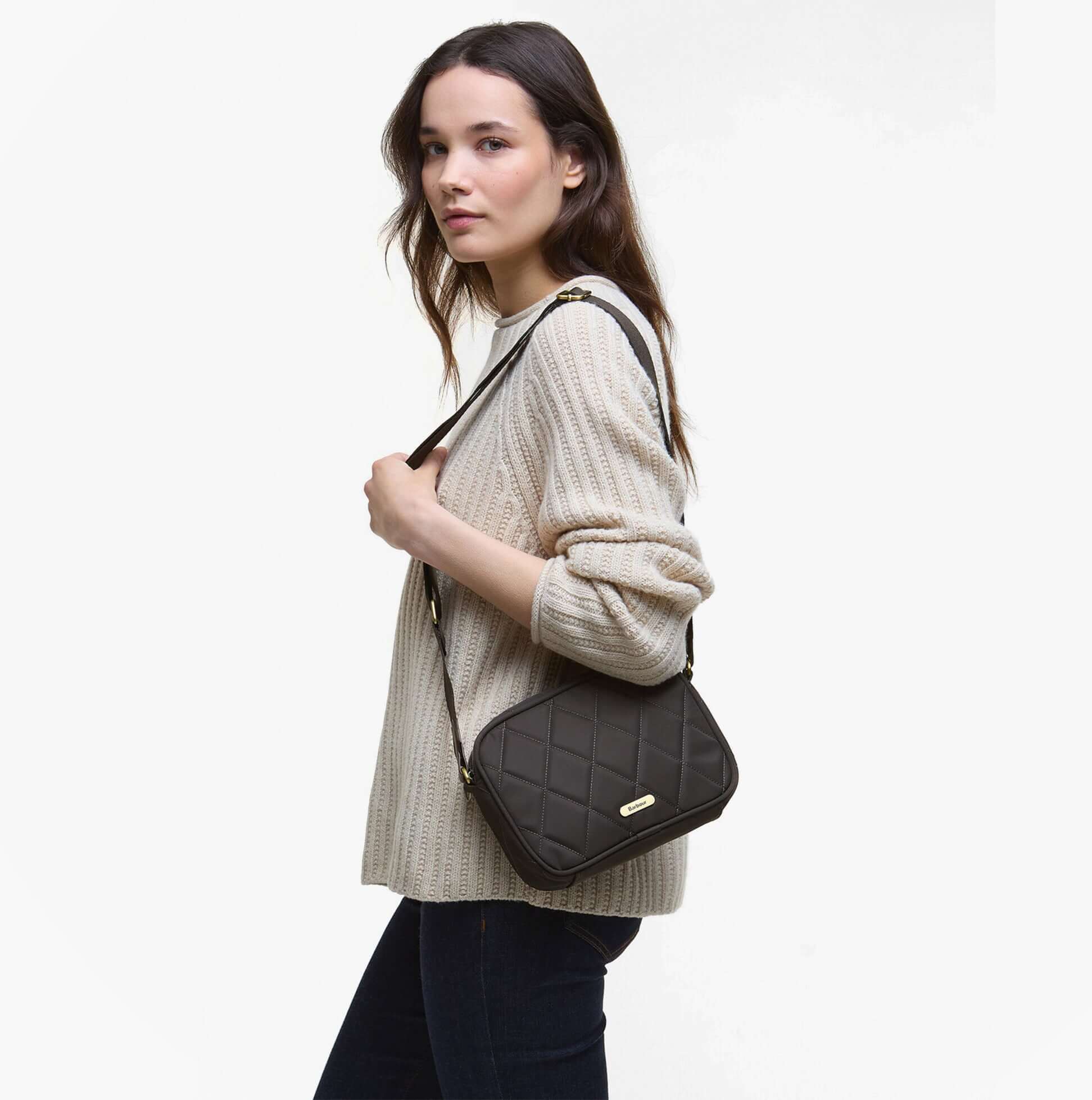 Barbour QUILTED Crossbody Bag Womens Olive side view on model wearing a beige sweater, showcasing the quilted design and strap.