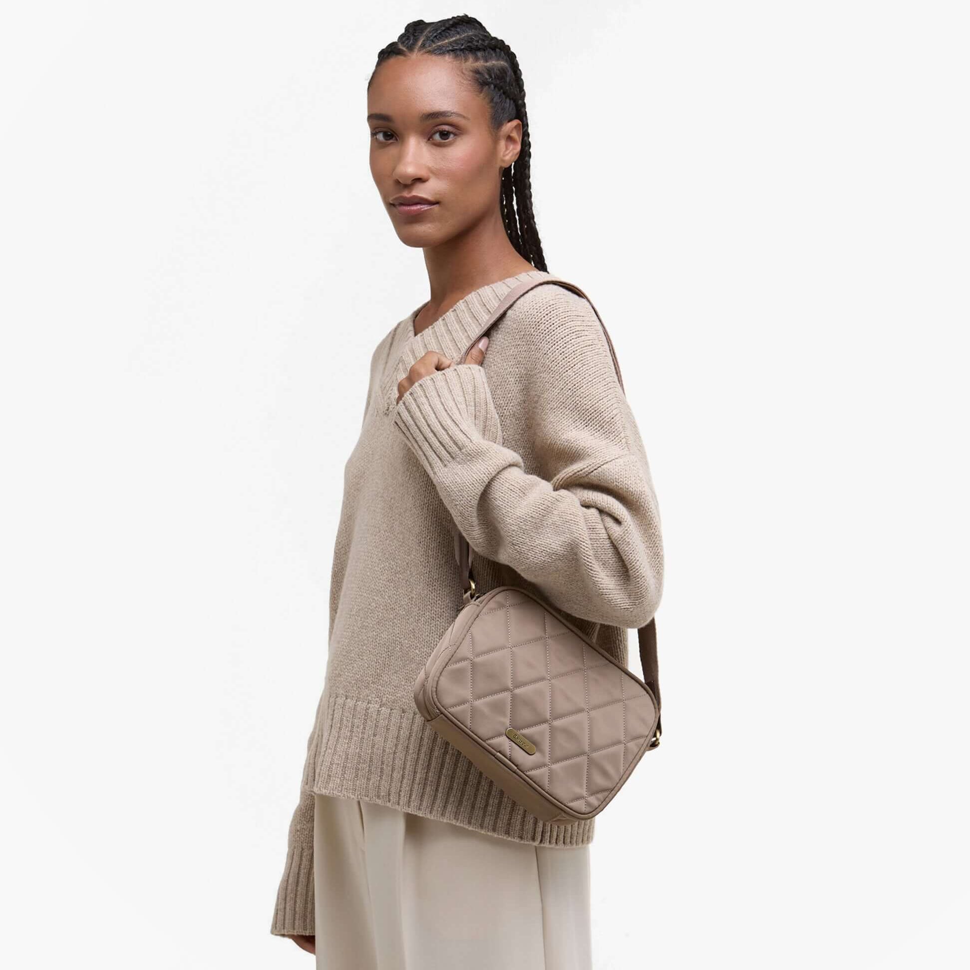 Barbour QUILTED Womens Crossbody Bag New Sand on model's shoulder, side view showing bag's quilted design and strap.