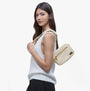 Barbour B.INTL MICRO QUALIFY Womens Crossbody Bag Light Pearl side view on model, showcasing zip closure and adjustable strap.