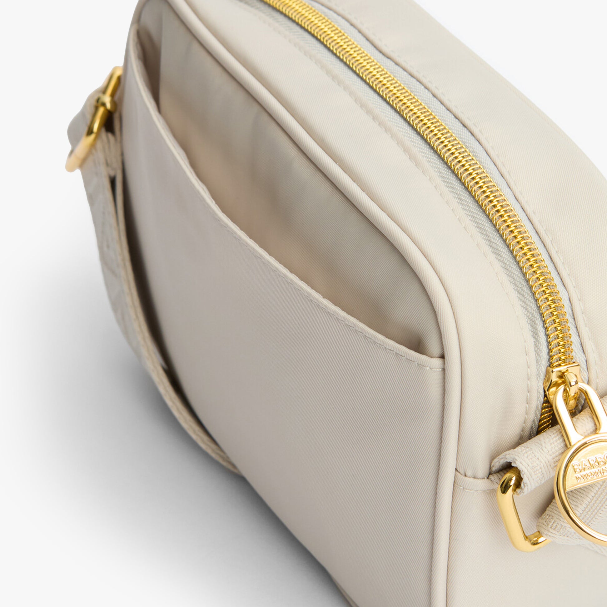 Barbour B.INTL MICRO QUALIFY Womens Crossbody Bag Light Pearl side view showing zip and pocket details.