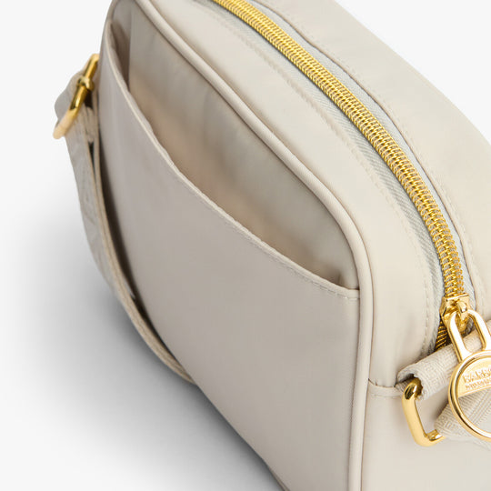 Barbour B.INTL MICRO QUALIFY Womens Crossbody Bag Light Pearl side view showing zip and pocket details.