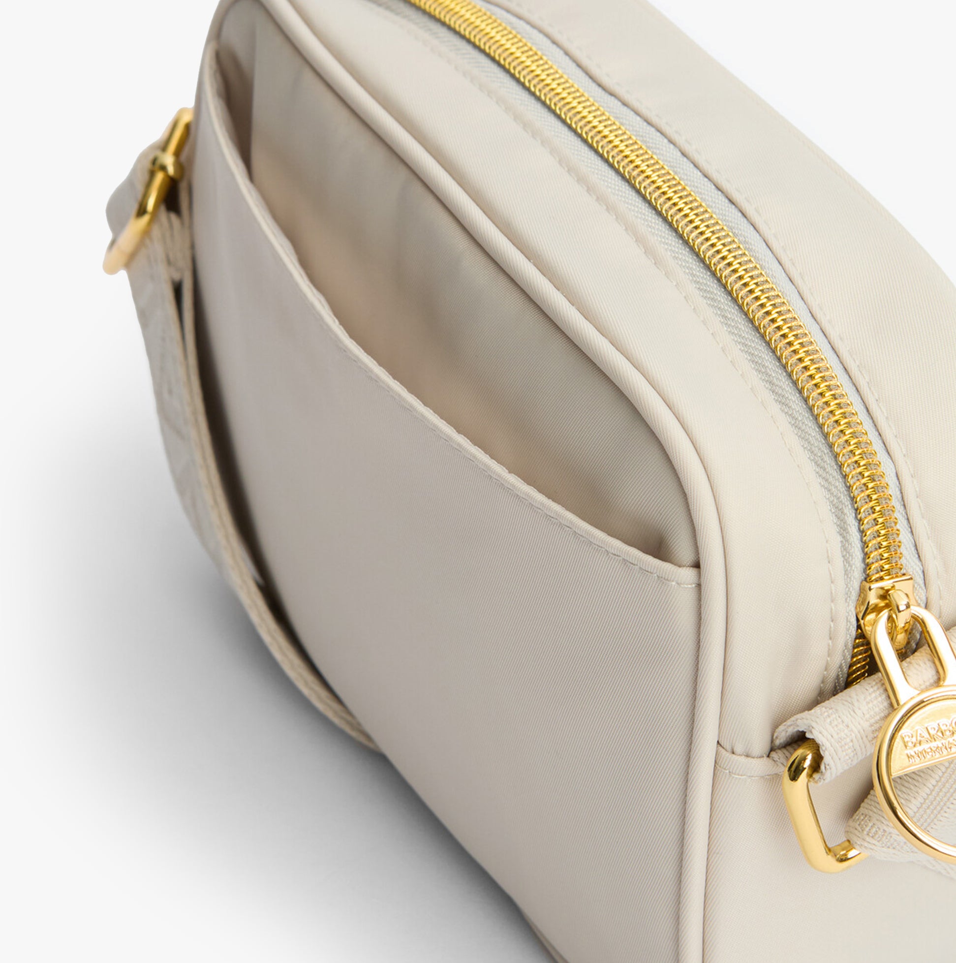 Barbour B.INTL MICRO QUALIFY Womens Crossbody Bag Light Pearl side view showing zip and pocket details.