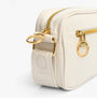 Barbour B.INTL MICRO QUALIFY Womens Crossbody Bag Light Pearl side view with adjustable strap and gold hardware.