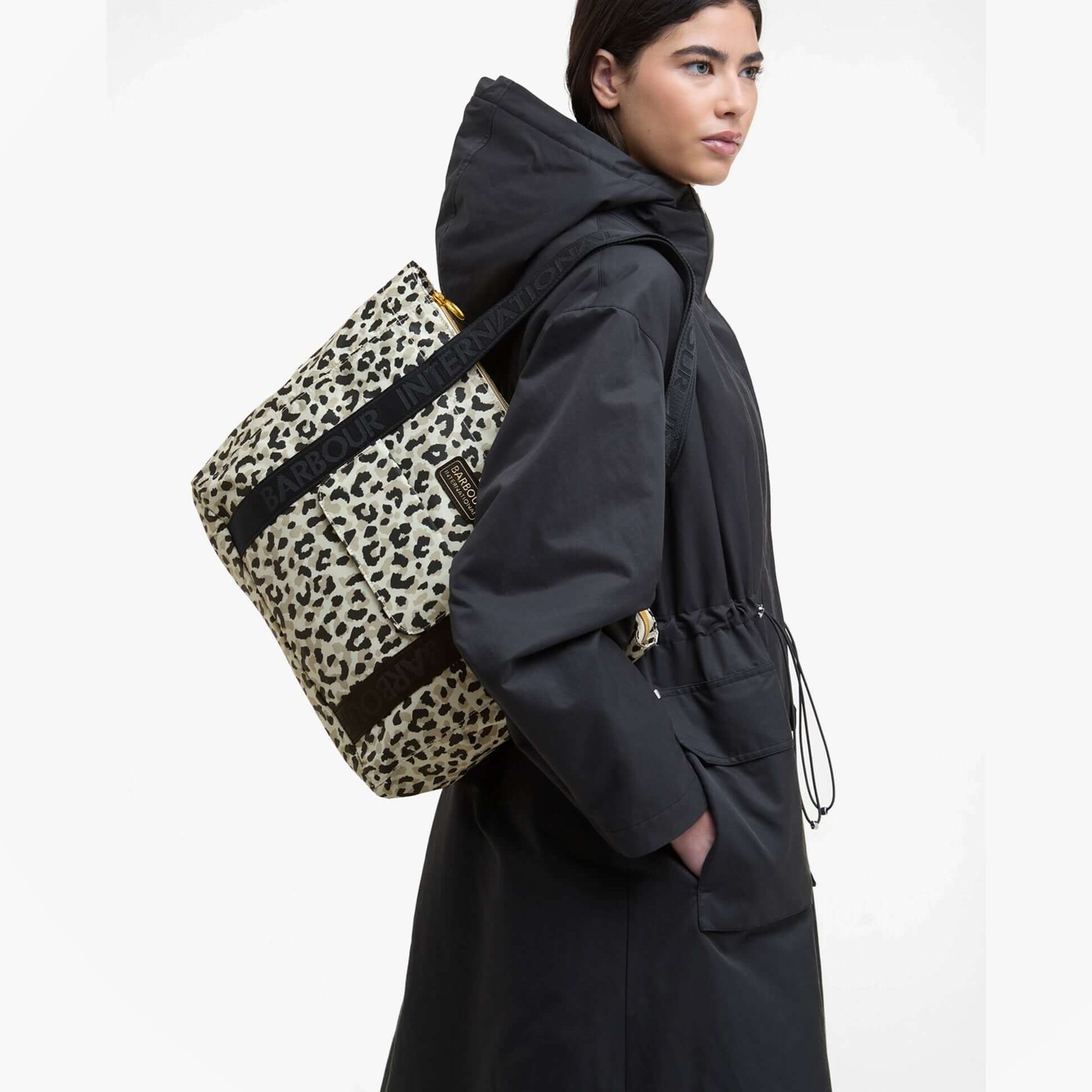 Barbour BOULEVARD Tote Bag Womens Jasmine Leopard side view with model wearing a black coat, showcasing the leopard print design.