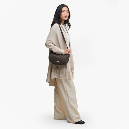 Barbour QUILTED SLING Womens Shoulder Bag Olive side view with model, showcasing its quilted design and stylish appearance.