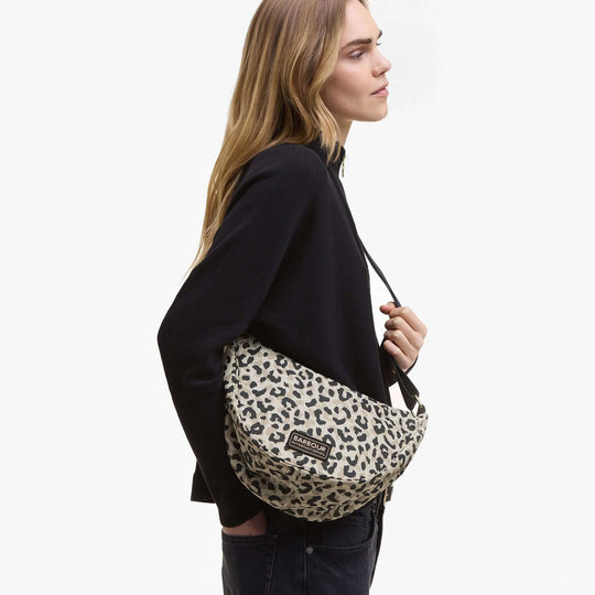 Barbour BOULEVARD Sling Bag Womens Jasmine Leopard side view on model, showcasing leopard print and zip closure.