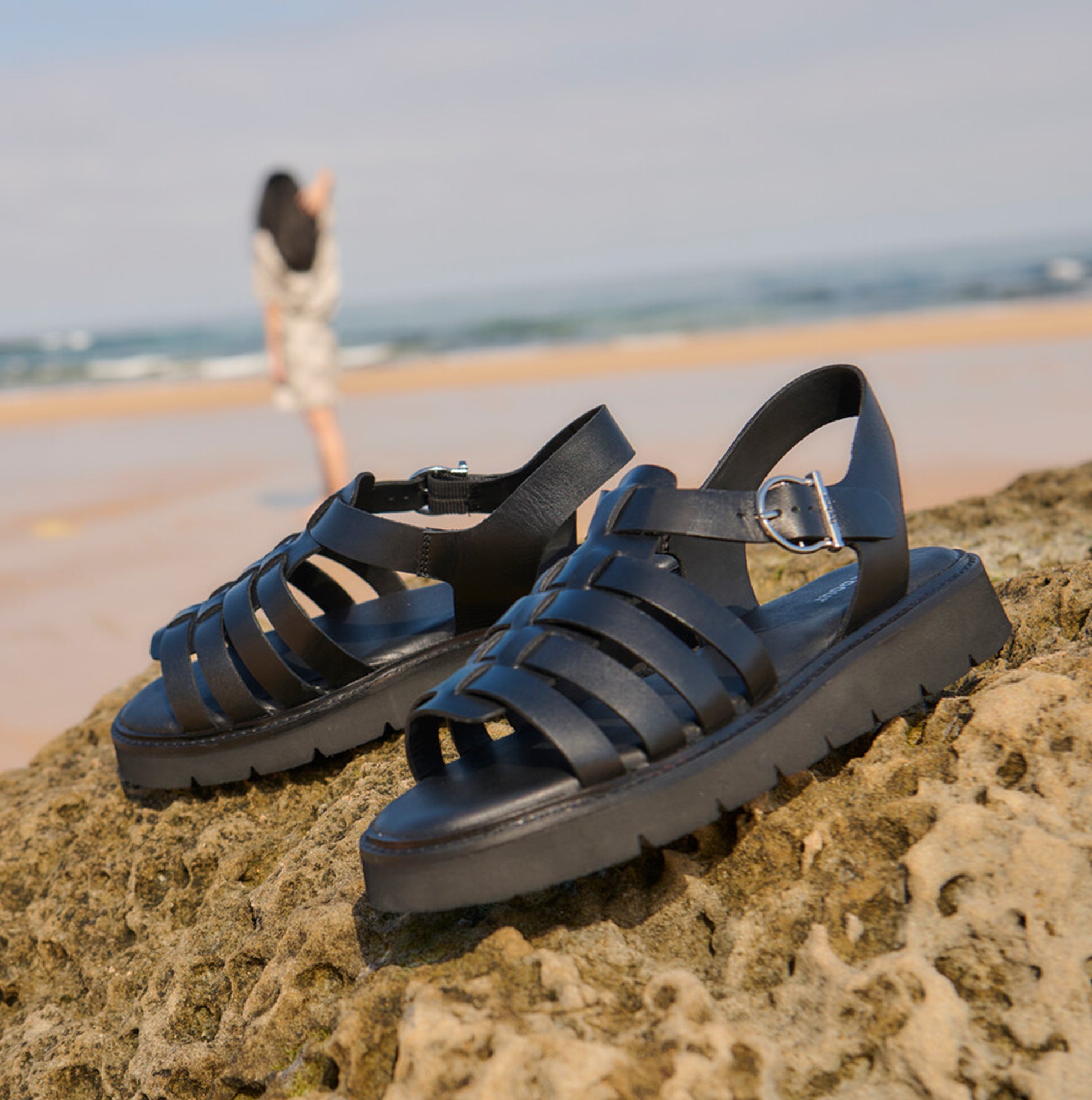Barbour OTTERBURN Womens Fisherman Sandals Black side view on rocky beach with model in background