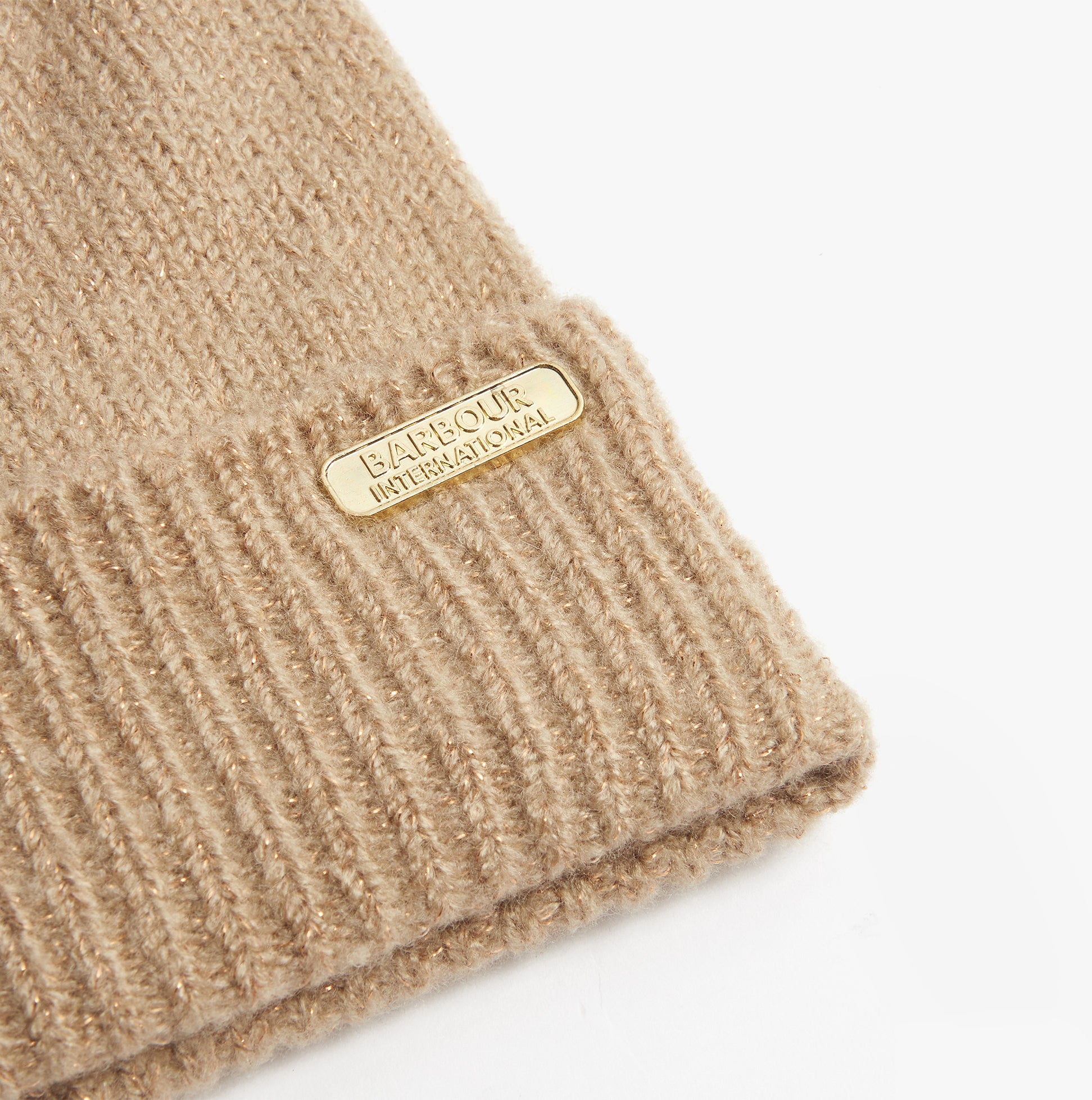 Barbour SPARKLE BEANIE & SCARF Womens Gift Set Oat detail view of the beanie with logo tag on a beige background.