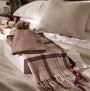 Barbour DOVER BEANIE & HAILES SCARF Gift Set Womens Muted Cabernet, front view of beanie and scarf set on a bed.