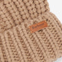 Barbour SALTBURN Womens Pom-Pom Beanie Mink detail view showing chunky-knit style and logo-embossed leather badge.
