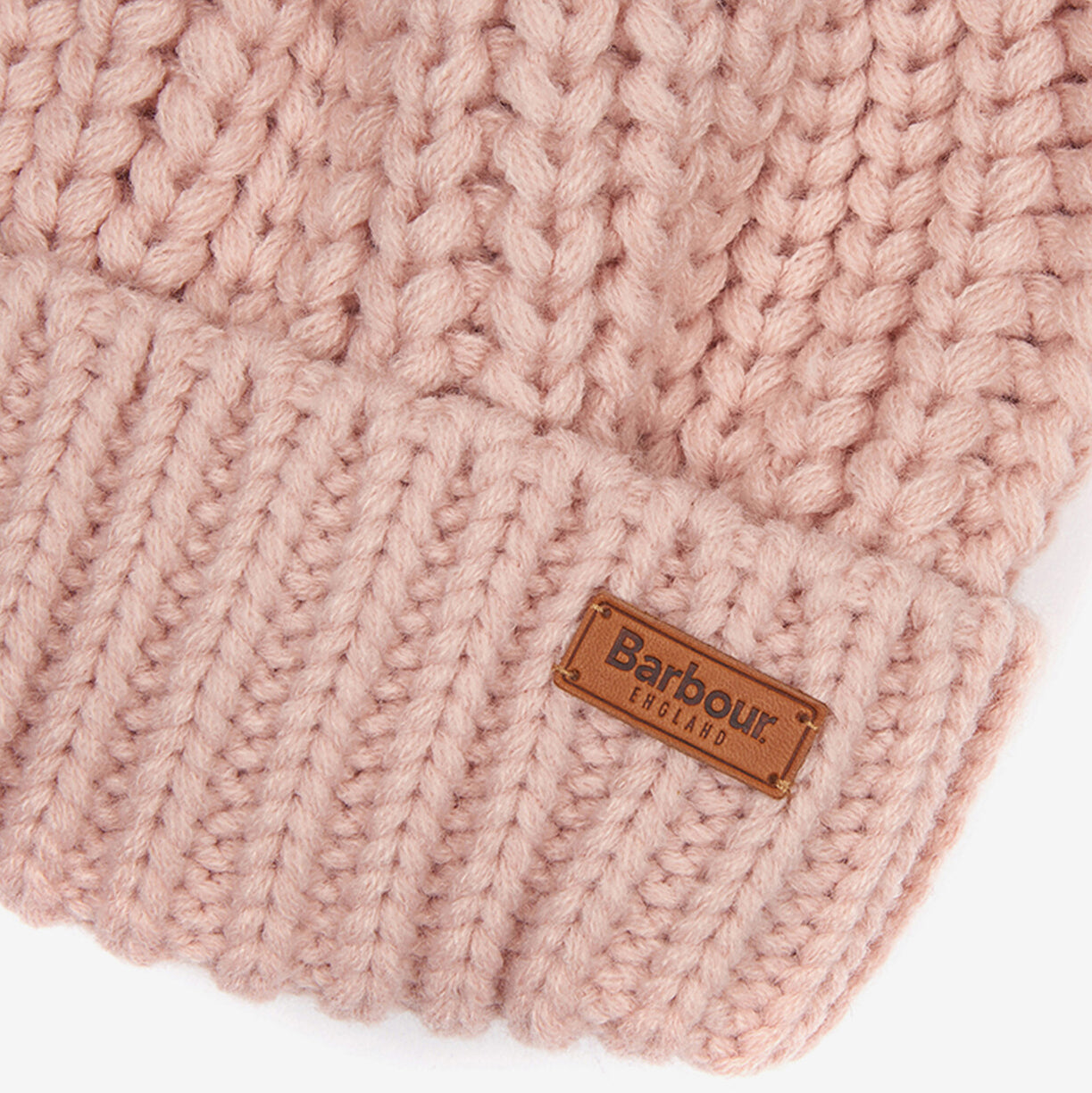 Close-up detail view of Barbour SALTBURN Womens Pom-Pom Beanie Pink showing the chunky knit and logo-embossed badge.