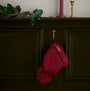 Barbour SALTBURN Womens Beanie Biking Red hanging on a hook with faux fur pom, stylish knit design.
