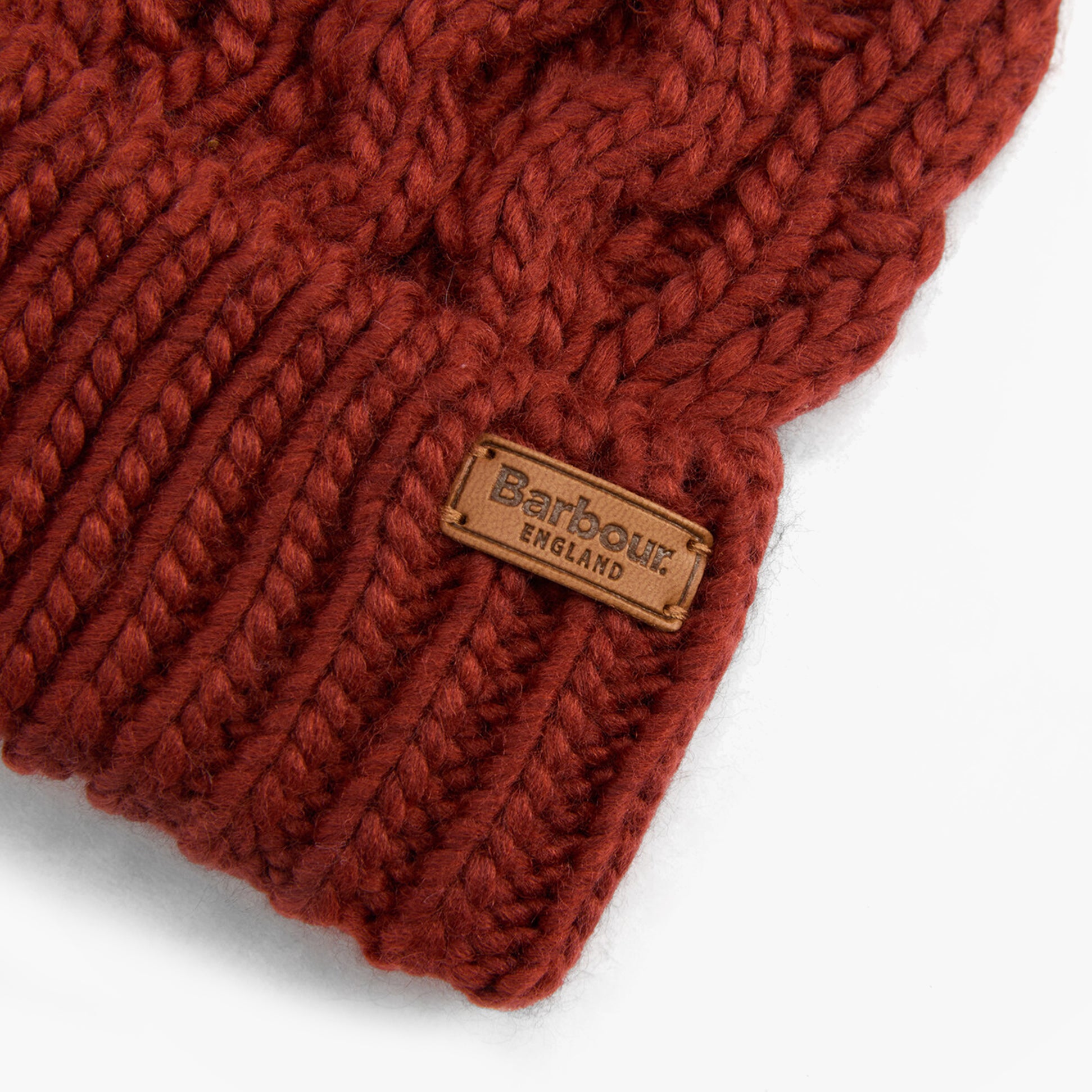 Barbour PENSHAW Womens Beanie Burnt Henna close-up view highlighting the knitted texture and brand label.