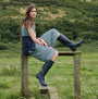 Barbour BEDE Womens Tall Wellington Boots Navy side view worn by model sitting on fence in countryside