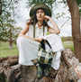 Barbour WILTON Womens Ankle Wellington Boots Classic Tartan worn by model sitting on a tree stump, side view, paired with plaid bag.