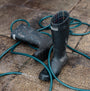 Barbour SNOWDON Womens Tall Wellies Black side view on muddy ground with garden hose.