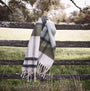 Barbour ISLA TARTAN BOUCLE Scarf Womens Soft Mint hanging on a wooden fence, showcasing the tartan pattern and tasselled trims.