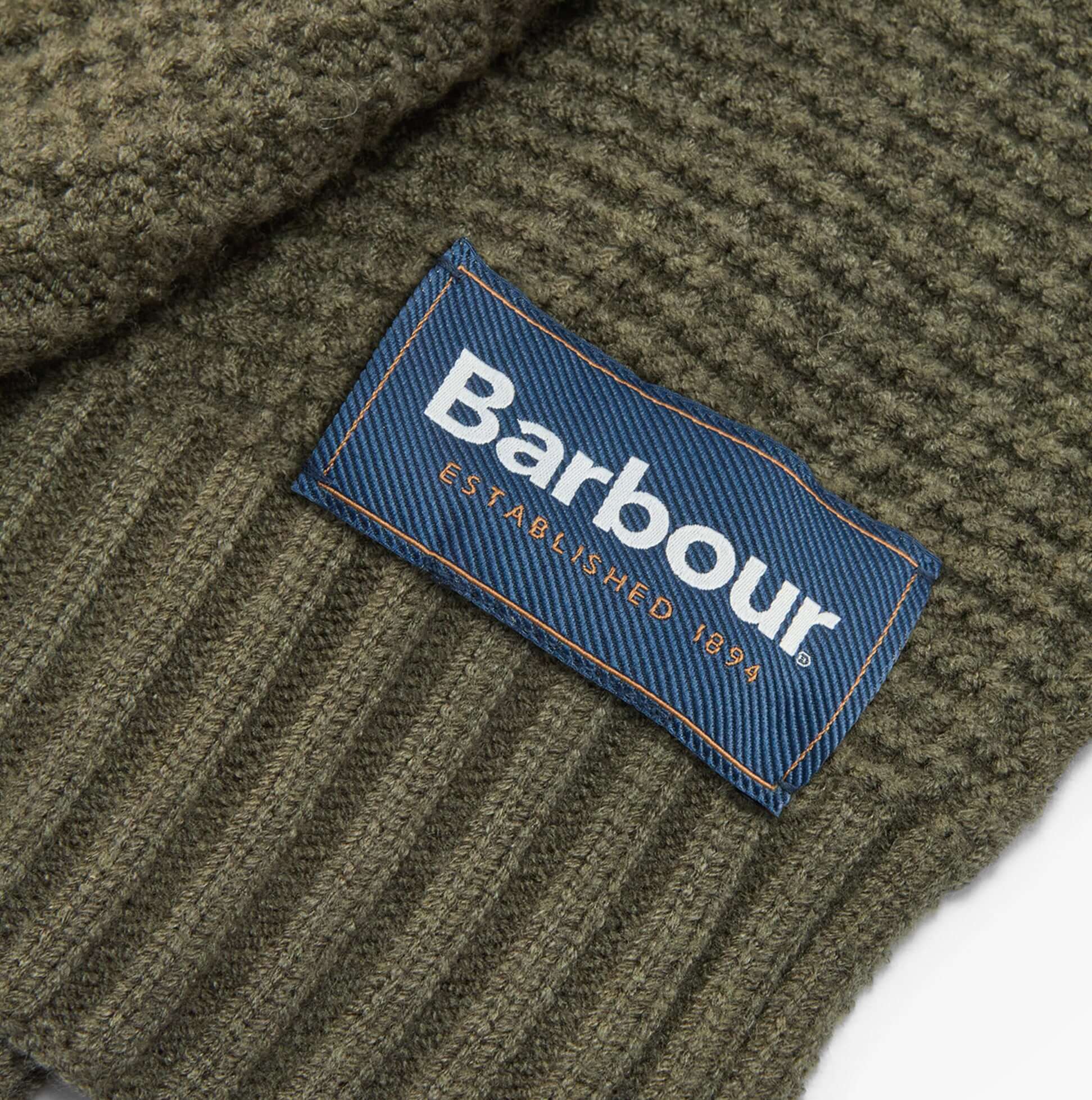 Close-up detail view of Barbour RAMSIDE BEANIE AND SCARF Mens Gift Set Dark Olive label.
