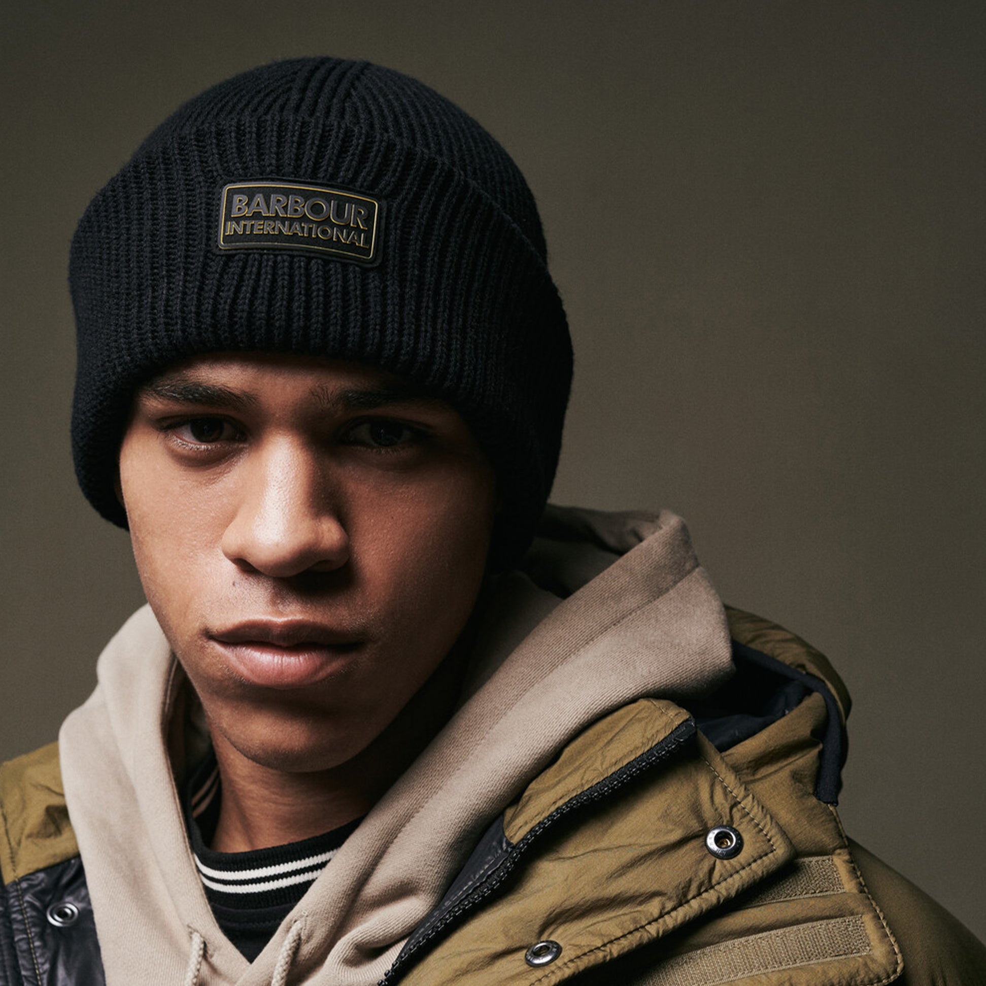 Barbour FLEX Mens Beanie Black worn by a model, front view showcasing the beanie's design and branding.