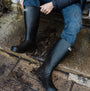 Barbour BEDE Mens Tall Wellington Boots Black side view worn outdoors, showcasing waterproof design and knee-high shaft.