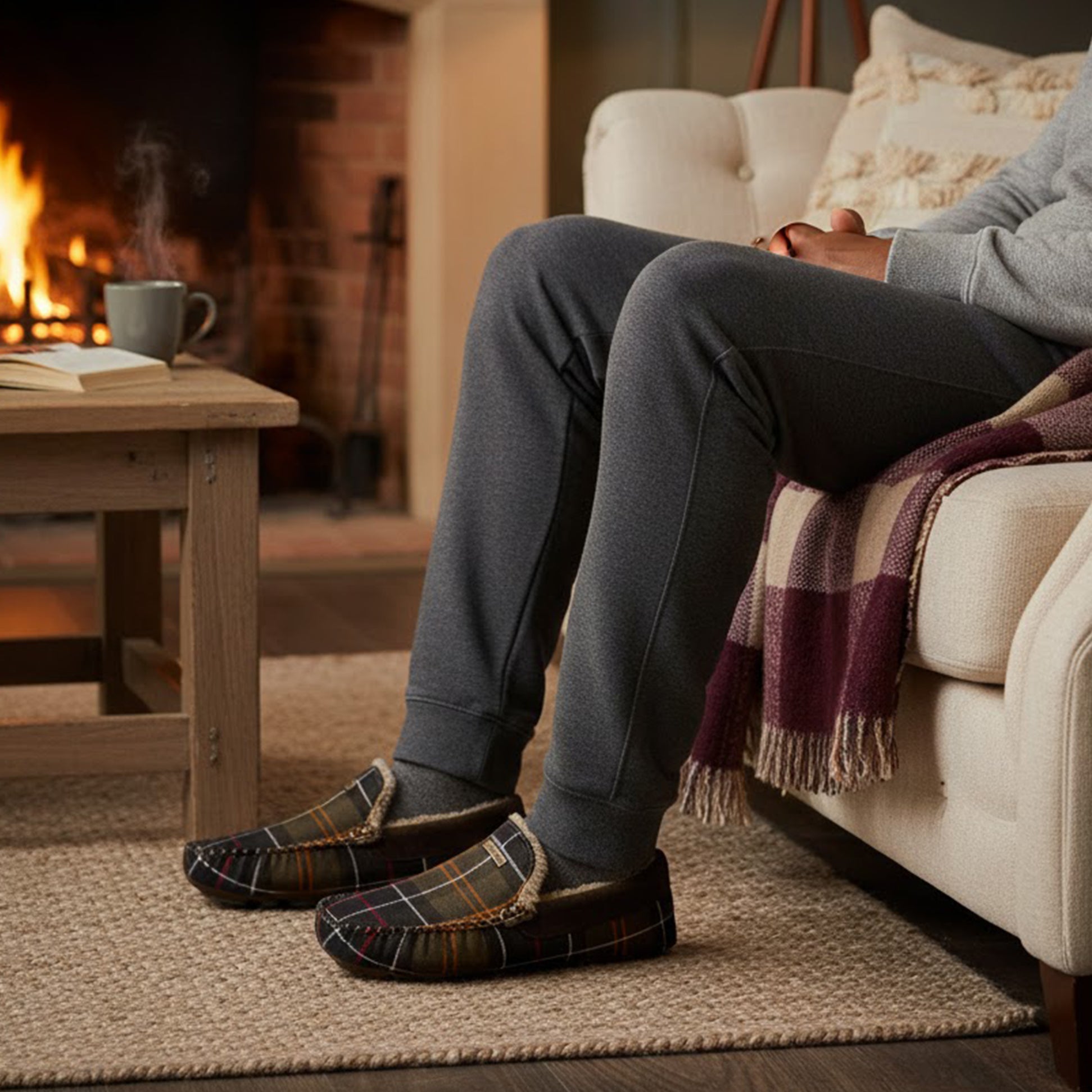 Barbour MONTY Mens Slippers Recycled Classic Tartan side view worn indoors near a fireplace, cozy atmosphere.