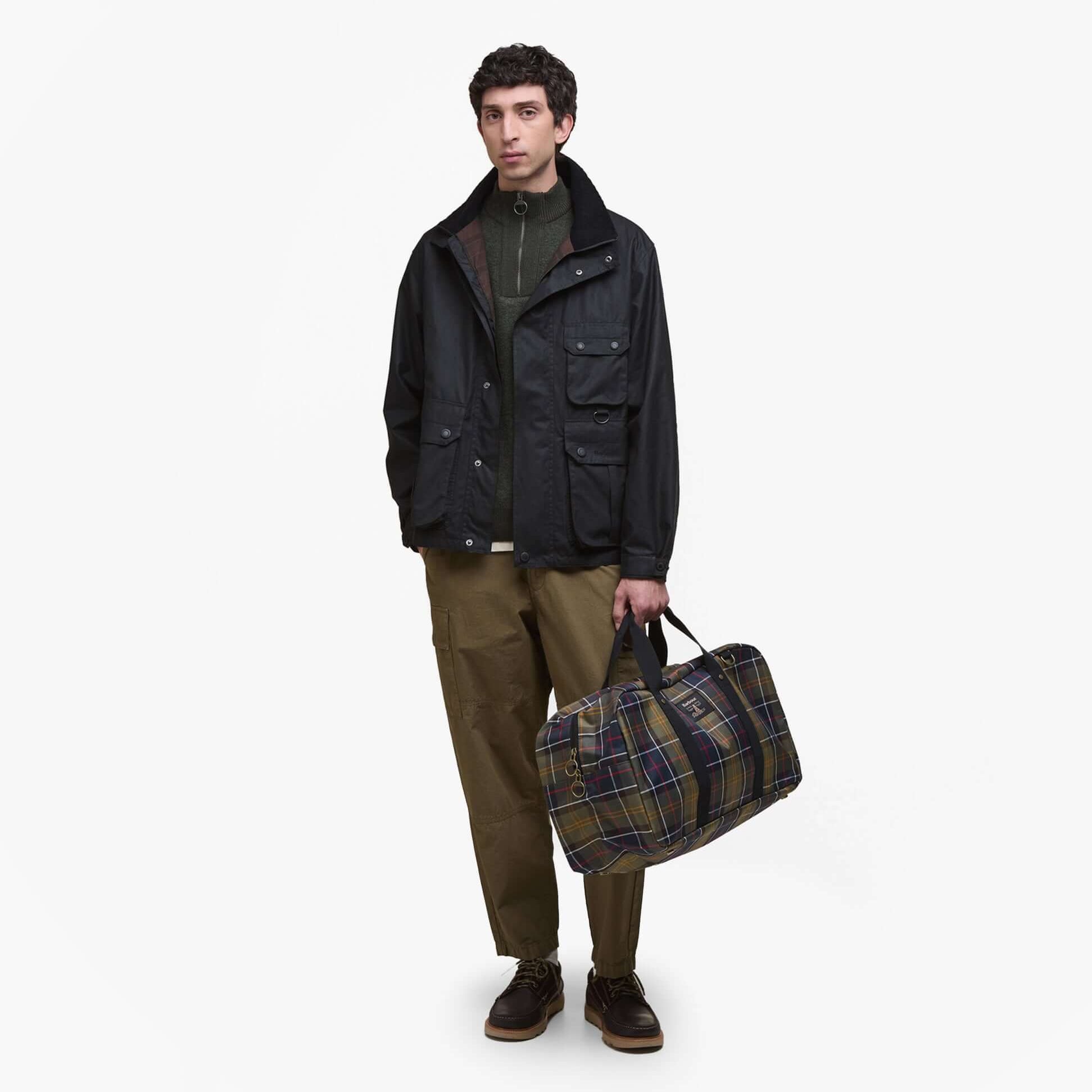 Barbour TORRIDON TARTAN Holdall Bag Classic Tartan front view with model, showcasing classic tartan design and zipper closure.