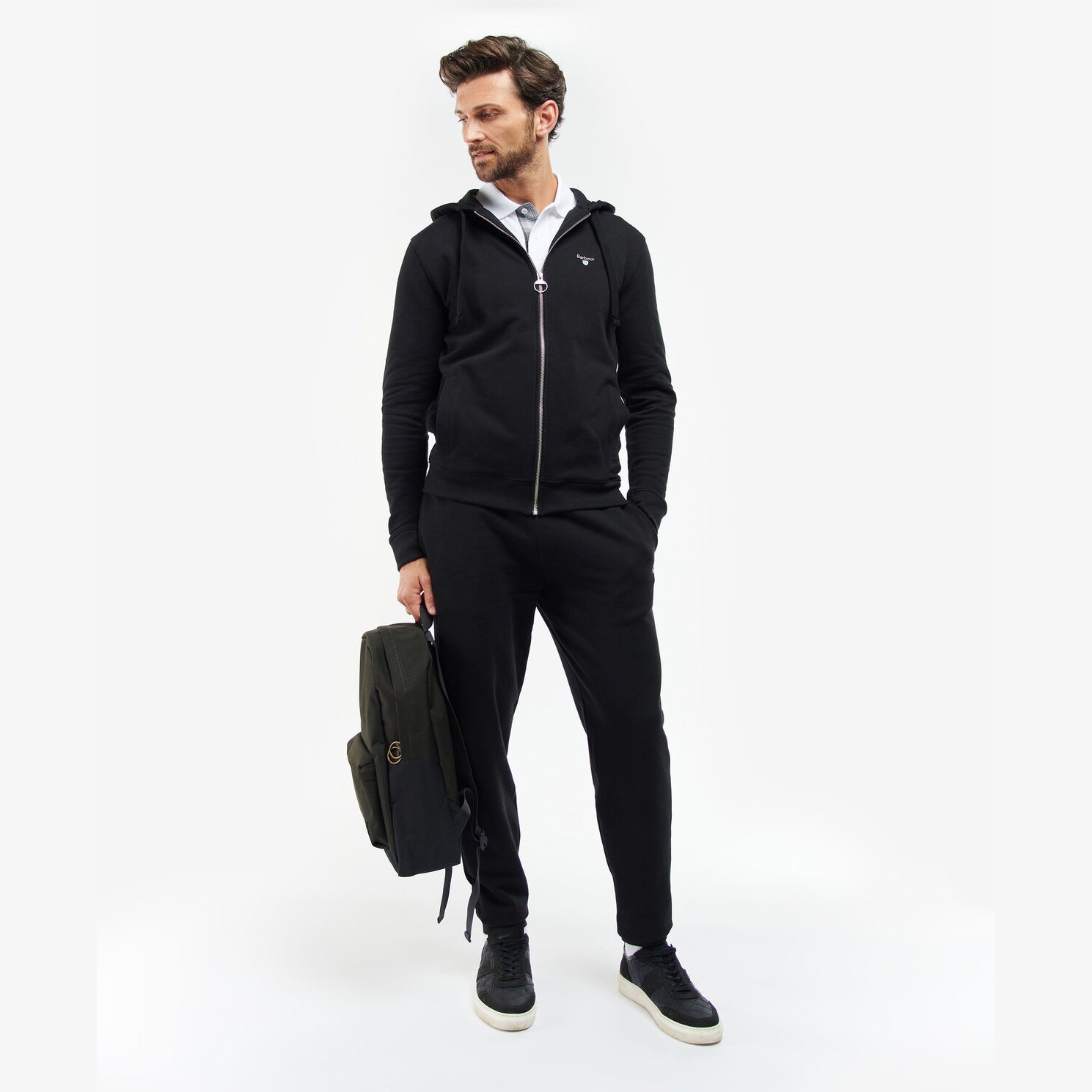 Barbour HIGHFIELD CANVAS BACKPACK Unisex Adults Canvas Backpack Navy/Olive side view with model wearing a black outfit.