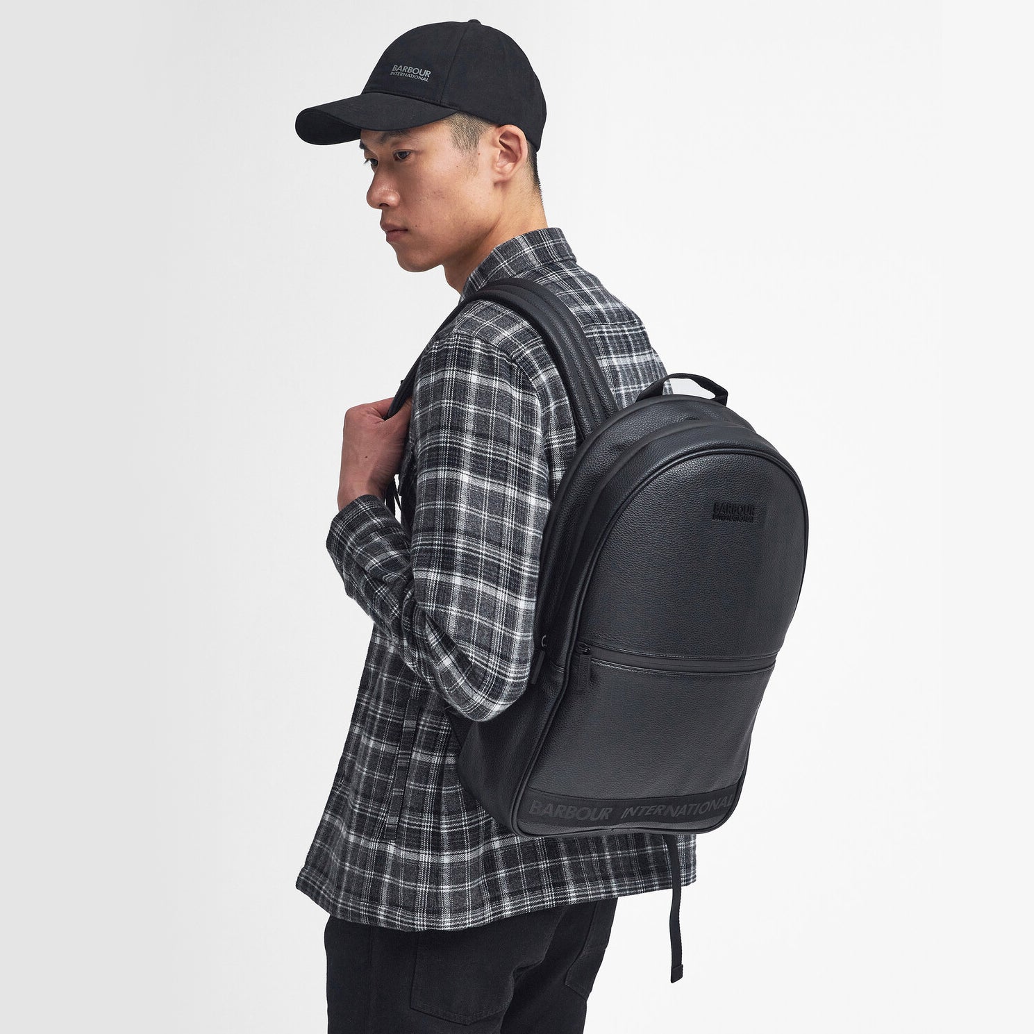 Barbour KILBURN BACKPACK Unisex Adults Backpack Black side view model wearing backpack on shoulder