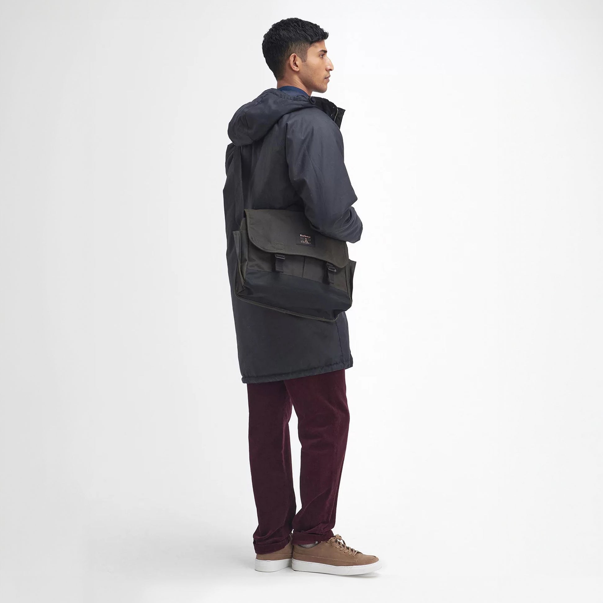 Barbour FIELD WAX Unisex Adults Messenger Bag Olive side view on model, showcasing adjustable strap and buckle closure.