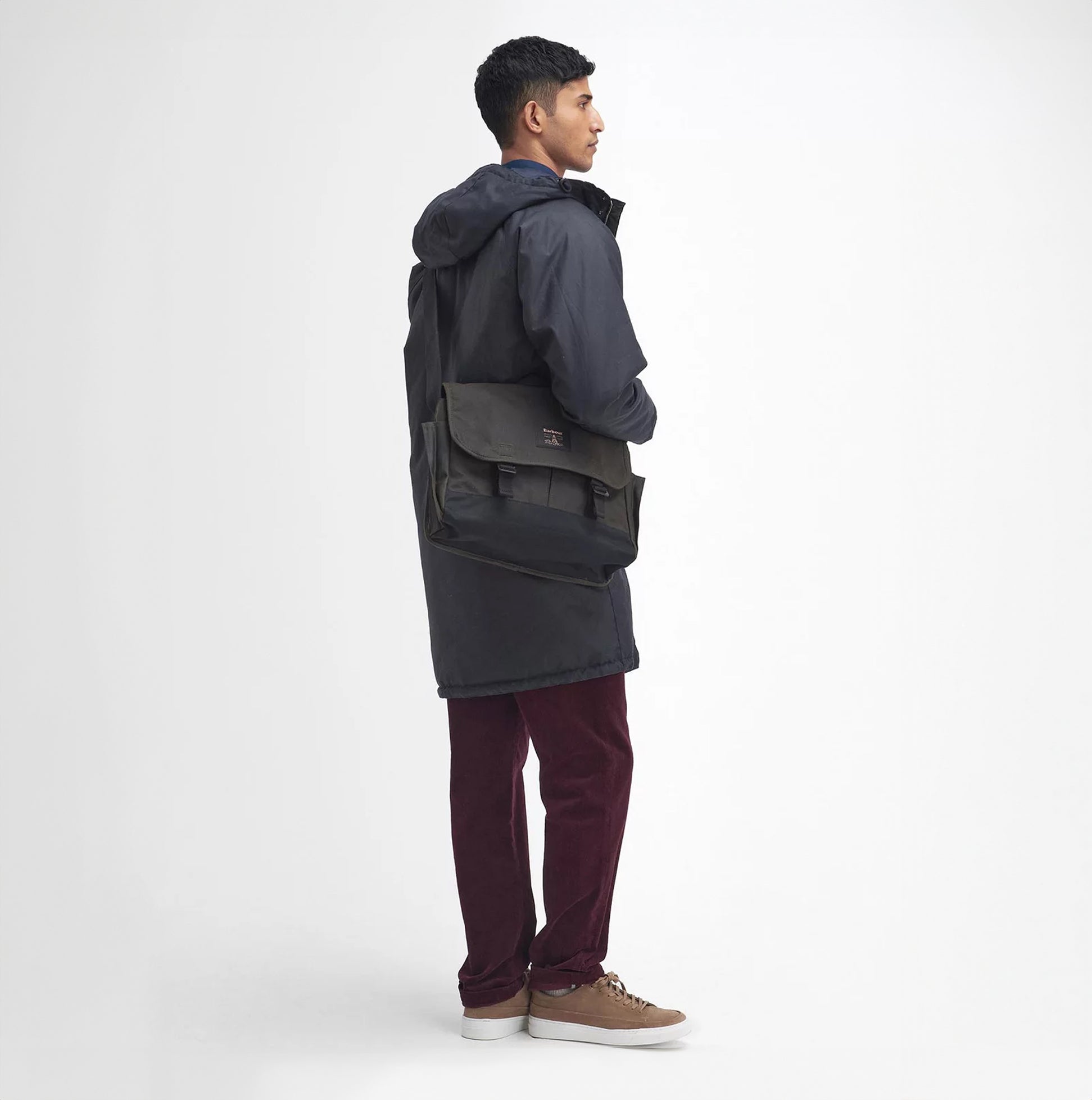 Barbour FIELD WAX Unisex Adults Messenger Bag Olive side view on model, showcasing adjustable strap and buckle closure.