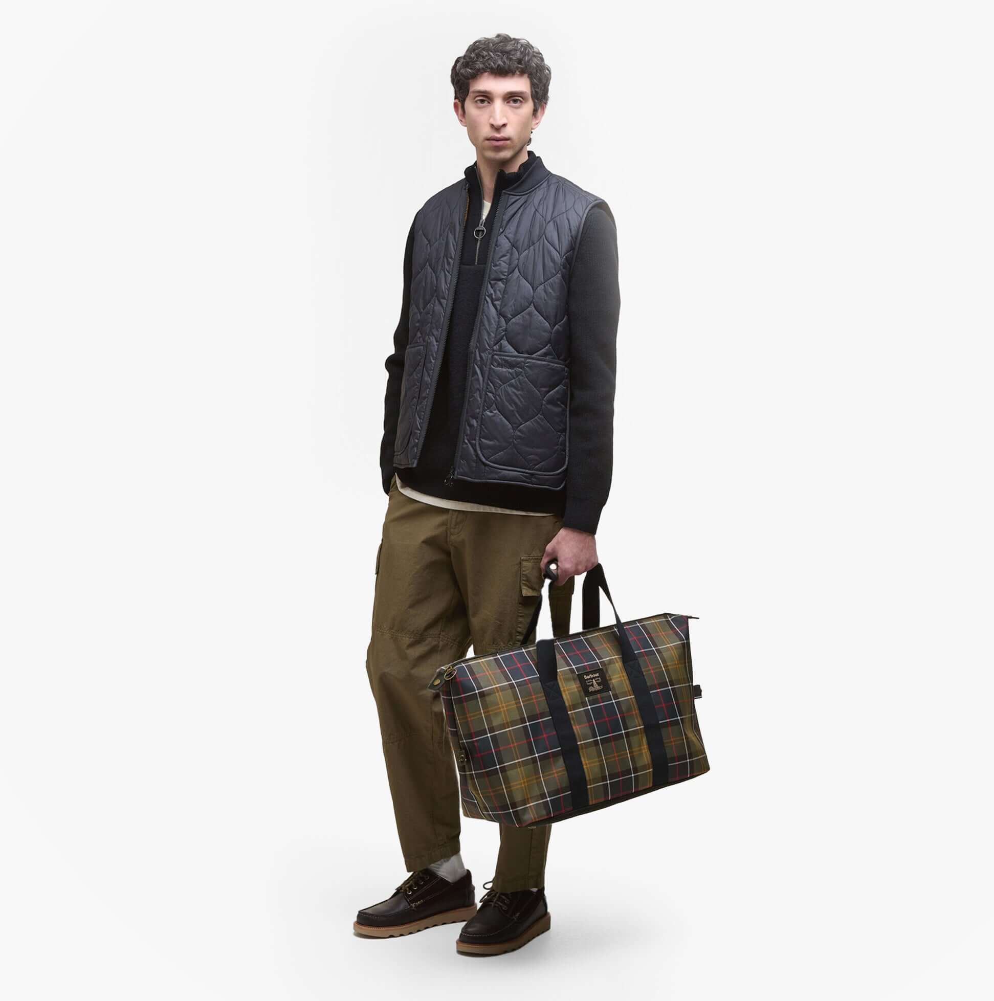 Barbour TORRIDON TARTAN Carry All Bag Classic Tartan front view held by a model, showcasing the classic tartan design.